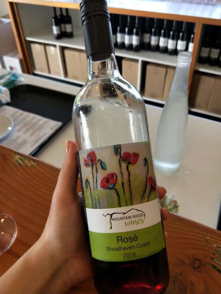 hand holding rose wine bottle in Shoalhaven Coast winery