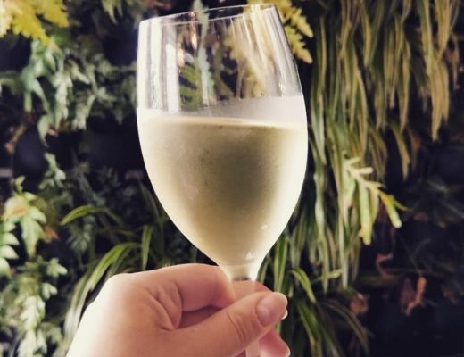 chardonnay white wine glass with green foliage background