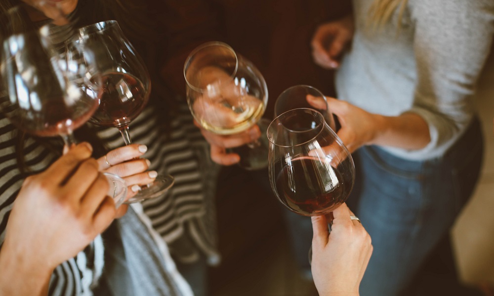 women holding wine glasses together