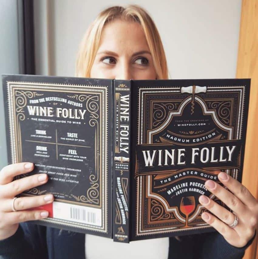 blonde woman in blue top holding wine book